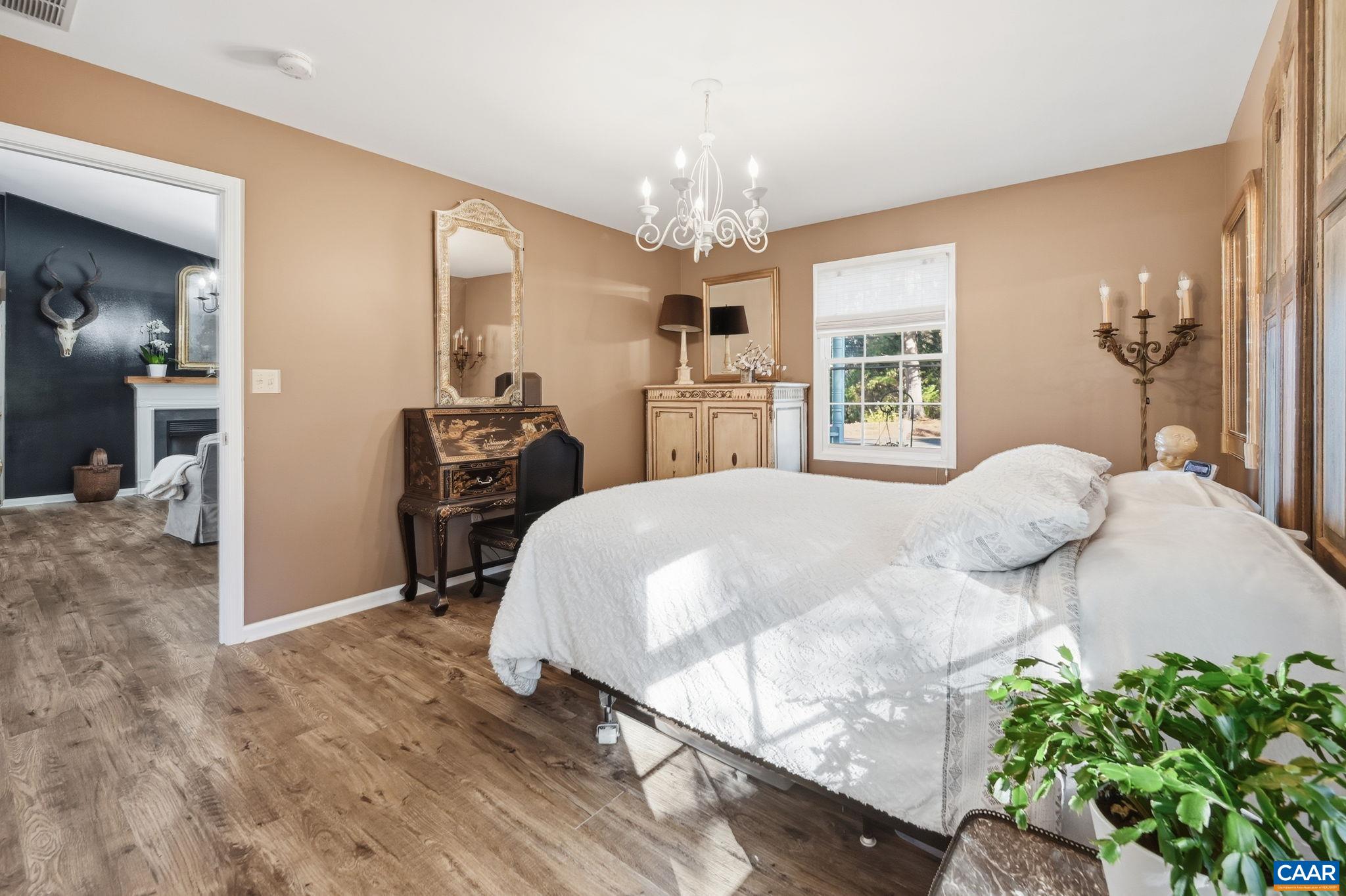 5356 Amicus Road Ruckersville, VA 22968 - Photo 18 of 46 a bedroom with a bed and a chandelier