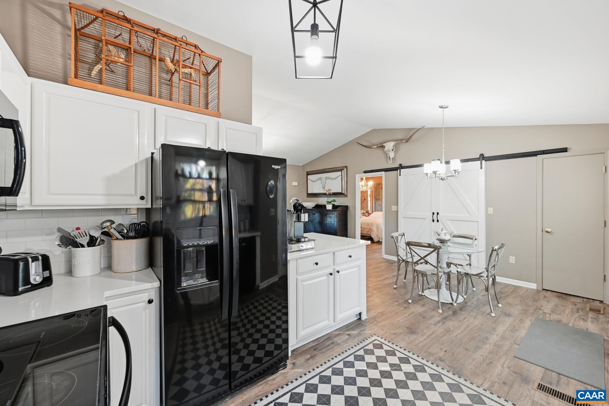 5356 Amicus Road Ruckersville, VA 22968 - Photo 29 of 46 a kitchen with stainless steel appliances a refrigerator a stove a sink dishwasher and white cabinets with wooden floor