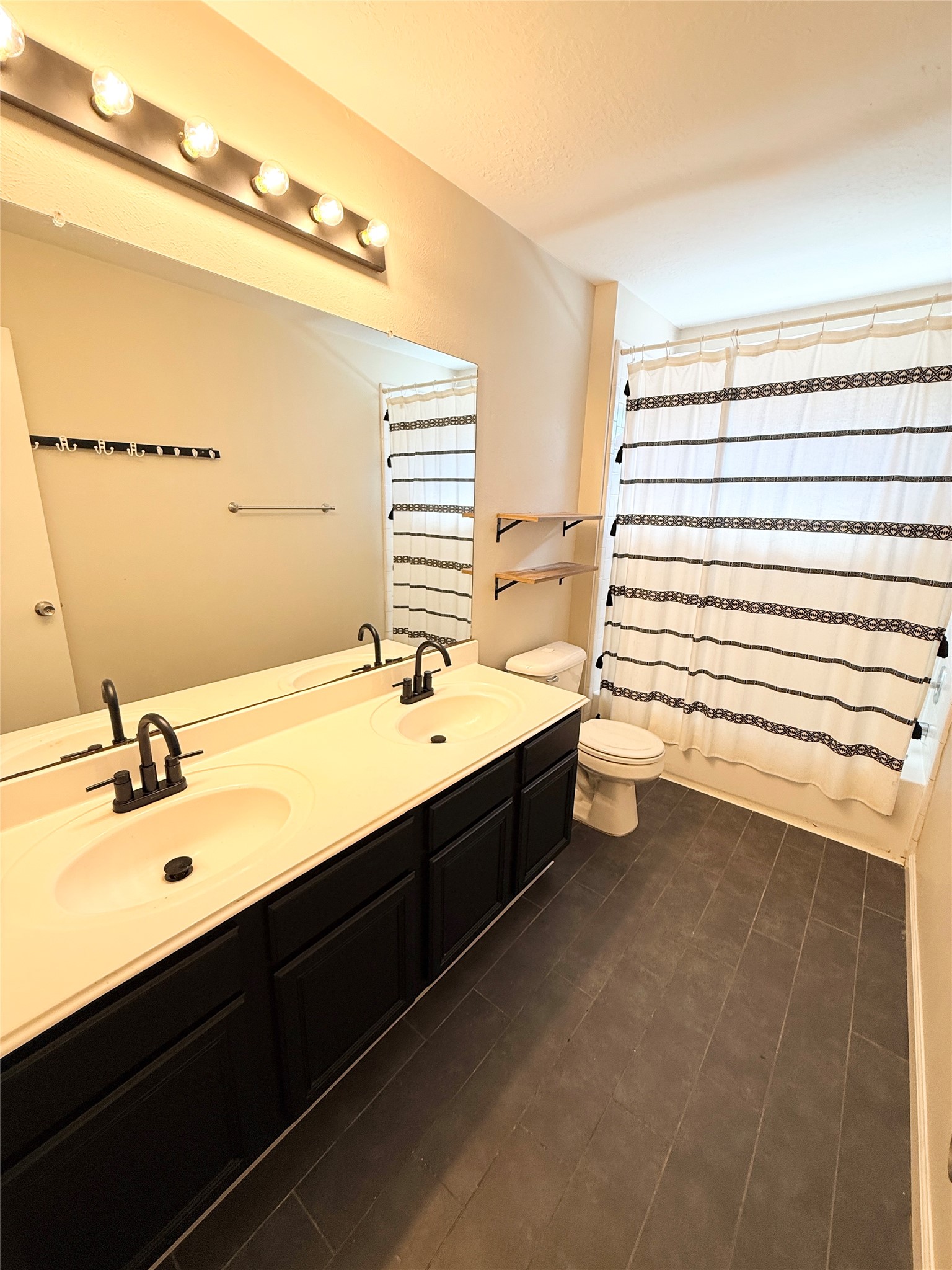 245 North Ranch House Road Angleton, TX 77515 - Photo 14 of 19 A bright and modern guest bathroom features a sleek vanity, stylish tile accents, and plenty of natural light.
