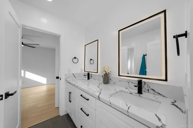 a bathroom with double vanity sinks and a mirror