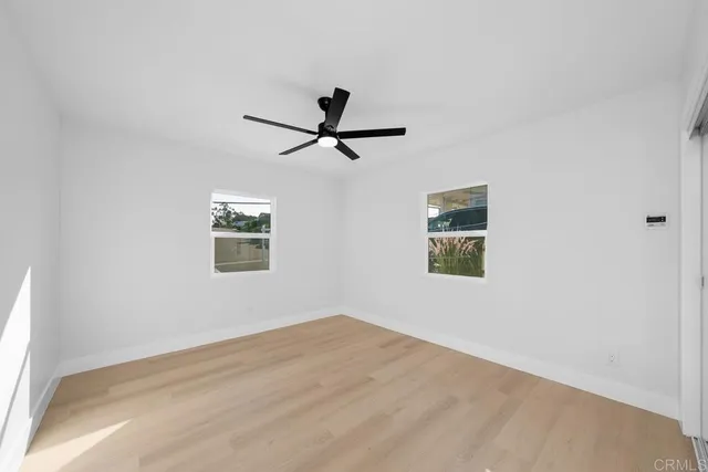 a view of a big room with wooden floor and a ceiling fan
