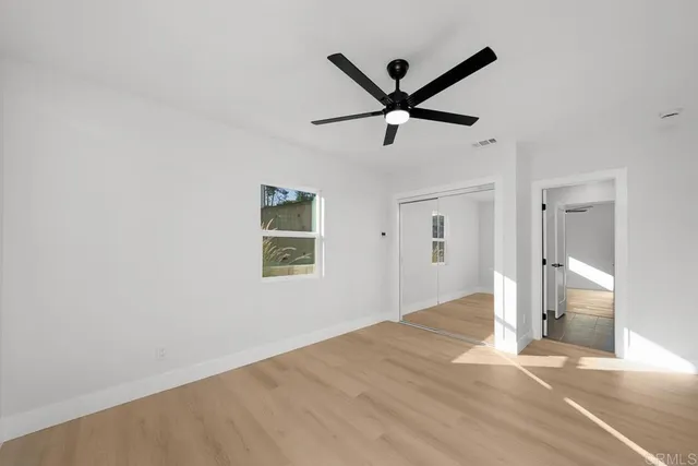 a view of a big room with wooden floor and windows