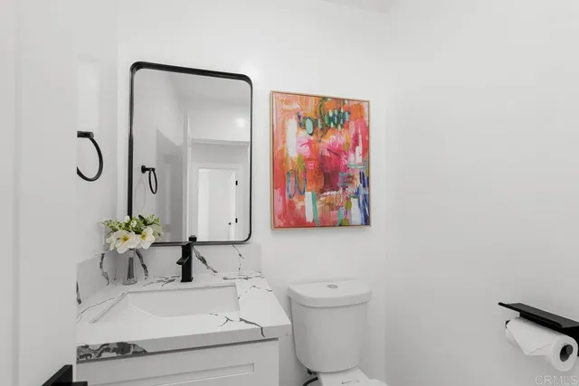 a bathroom with a sink mirror and toilet