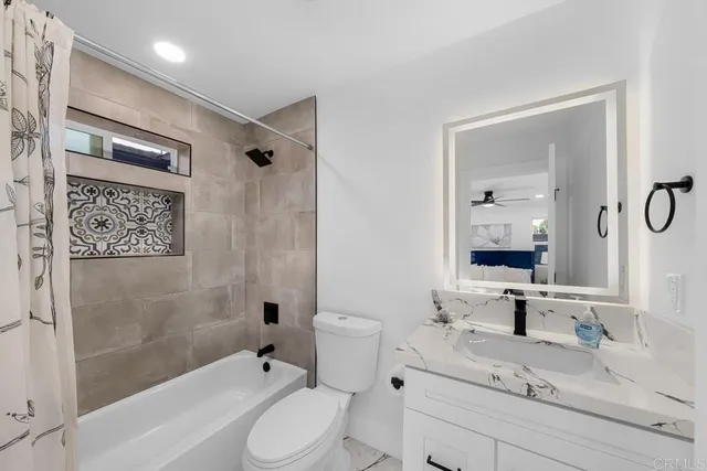 a bathroom with a granite countertop sink toilet and shower
