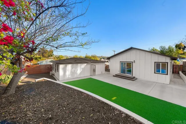 a view of backyard of house with wooden deck and seating
