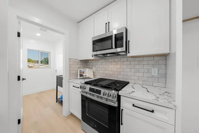 a kitchen with stainless steel appliances a stove microwave and sink