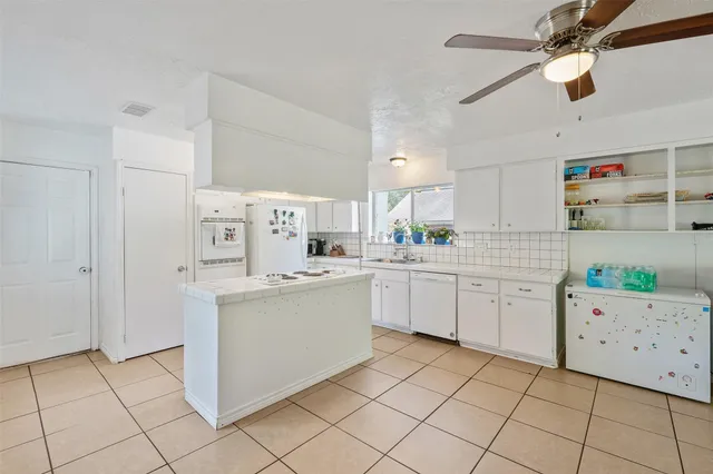a kitchen with a refrigerator a sink and cabinets