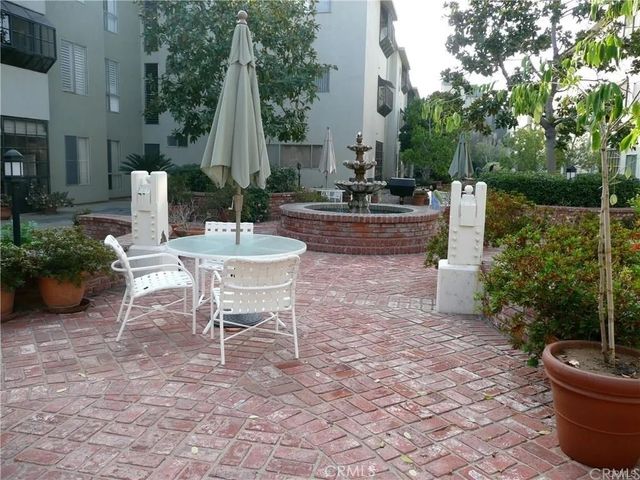 a backyard of a house with fountain table and chairs