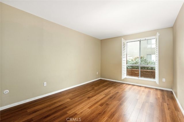 a front view of a building with a garden and trees
