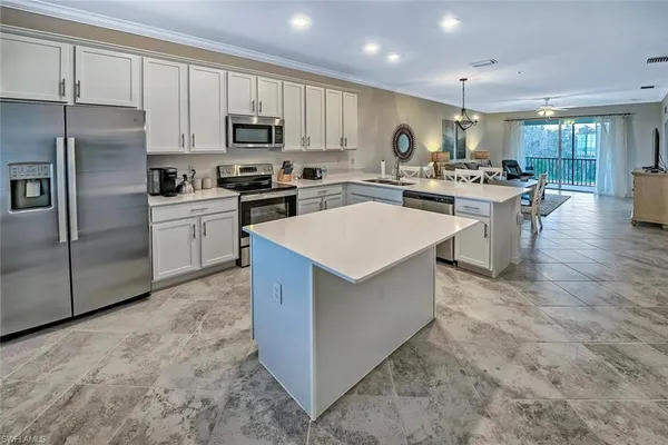 a kitchen with stainless steel appliances a refrigerator sink and microwave