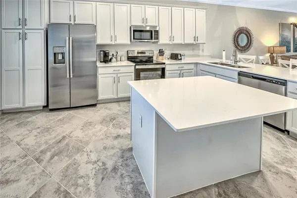 a kitchen with granite countertop a refrigerator and a sink