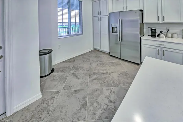 a kitchen with stainless steel appliances a stove a sink a microwave a refrigerator a window and white cabinets