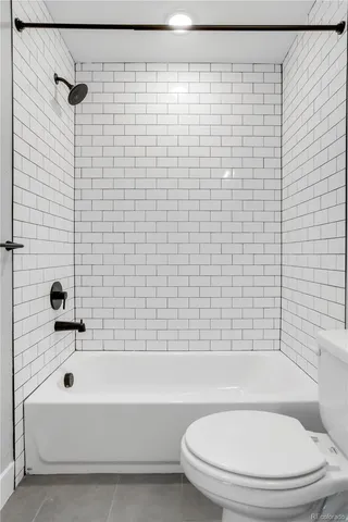 a bathroom with a white toilet and a bathtub