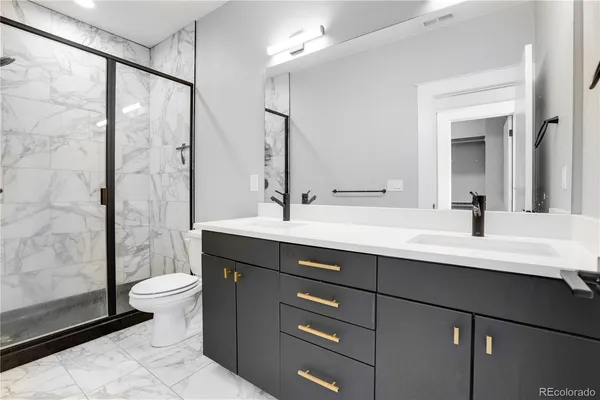 a bathroom with a double vanity sink toilet and a mirror