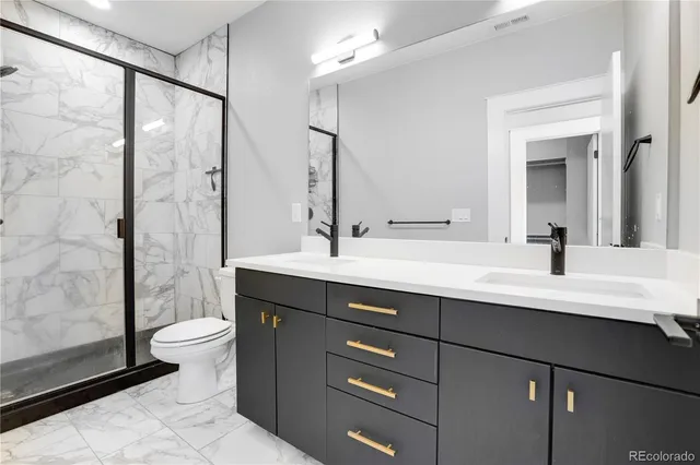 a bathroom with a double vanity sink toilet and a mirror