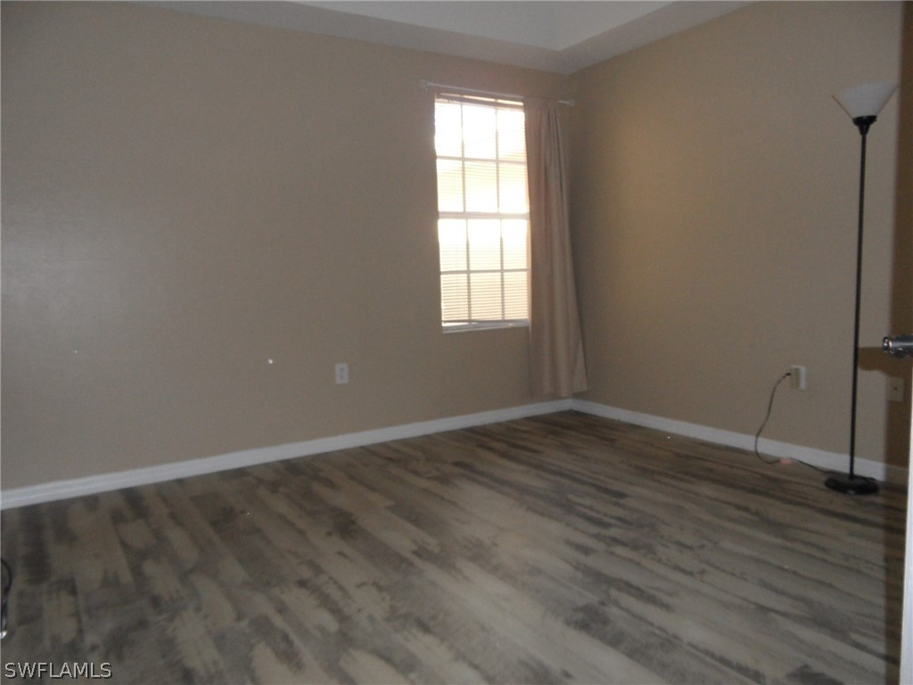 5430 Park Road, Unit 2 Fort Myers, FL 33908 - Photo 10 of 17 an empty room with wooden floor and windows