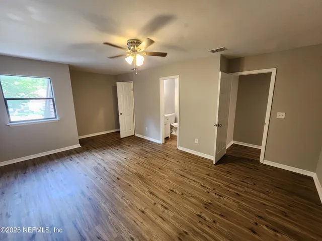 a view of empty room with wooden floor