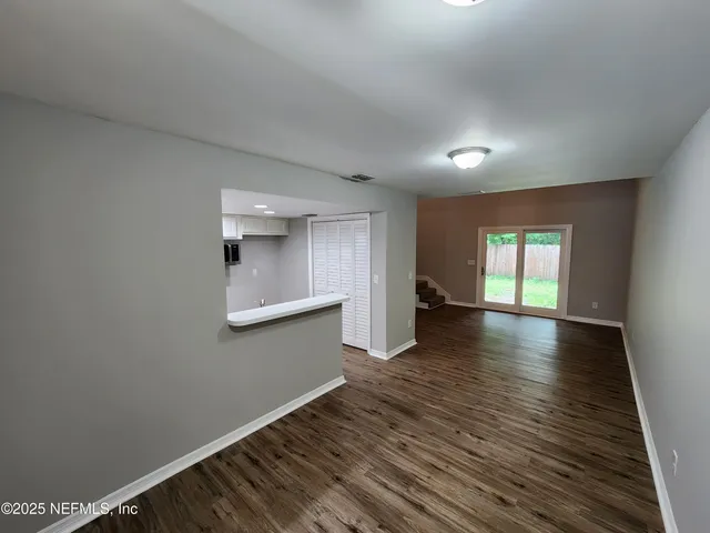 a view of a room with wooden floor and a window
