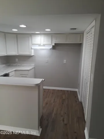 a view of a kitchen with an empty space and a window
