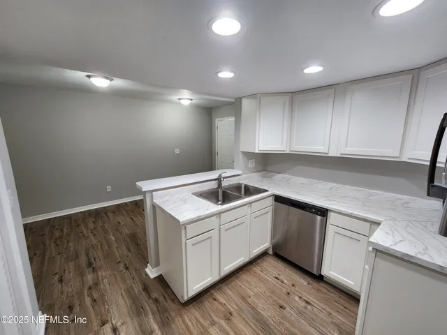 a kitchen that has a sink in it and wooden floors