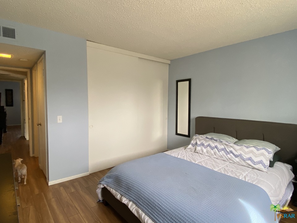 1268 Ramon Road, Unit 22 Palm Springs, CA 92264 - Photo 11 of 21 a bedroom with a bed and wooden floor
