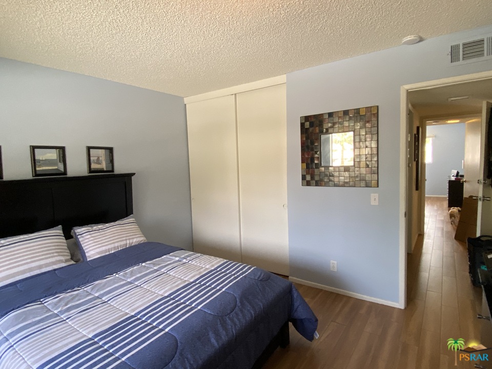 1268 Ramon Road, Unit 22 Palm Springs, CA 92264 - Photo 17 of 21 a bedroom with a bed and wooden floor