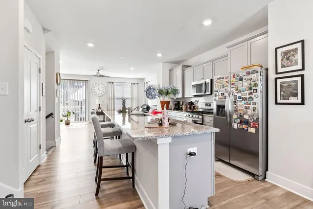 a kitchen with stainless steel appliances kitchen island granite countertop a refrigerator and a stove top oven