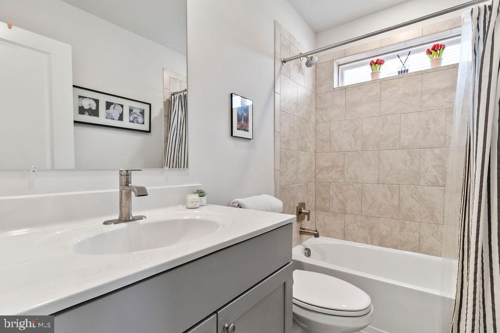 6882 Barrowfield Place Bryans Road, MD 20616 - Photo 20 of 34 a bathroom with a sink a toilet a mirror a vanity a bathtub and shower