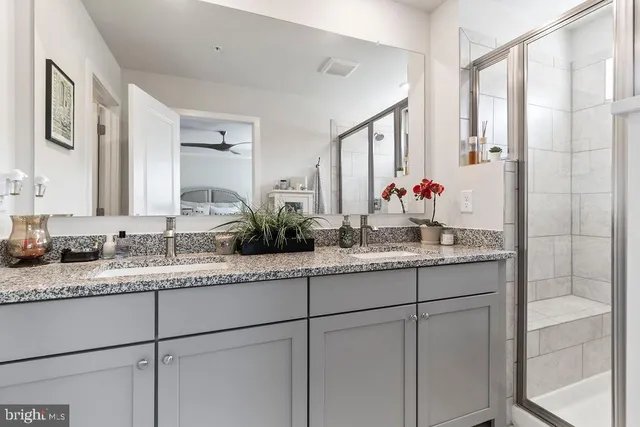 a bathroom with a granite countertop sink double vanity and a mirror