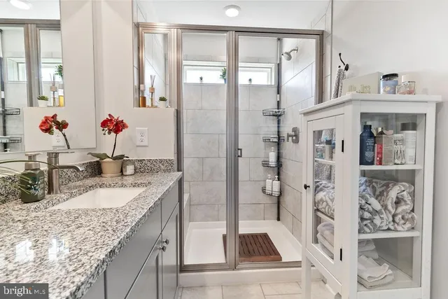 a bathroom with a granite countertop tub sink and mirror