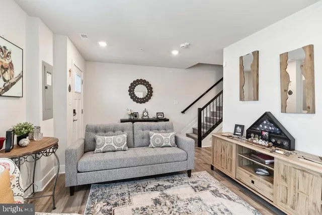 a living room with furniture and a wooden floor