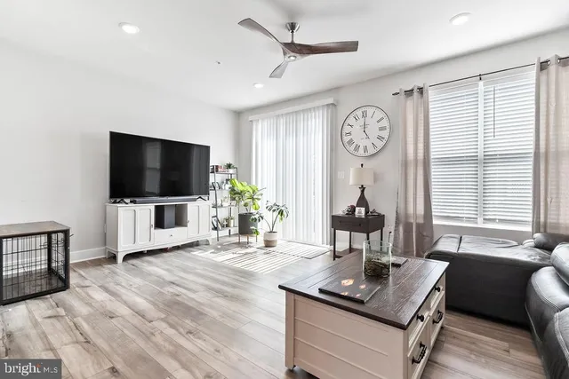 a living room with furniture a flat screen tv and a window