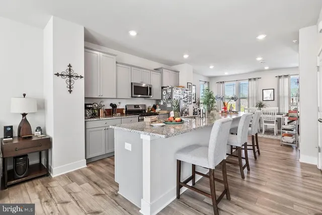 a kitchen with stainless steel appliances a microwave a stove a sink a refrigerator and cabinets