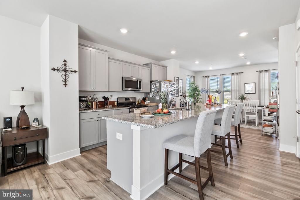 6882 Barrowfield Place Bryans Road, MD 20616 - Photo 8 of 34 a kitchen with stainless steel appliances a microwave a stove a sink a refrigerator and cabinets