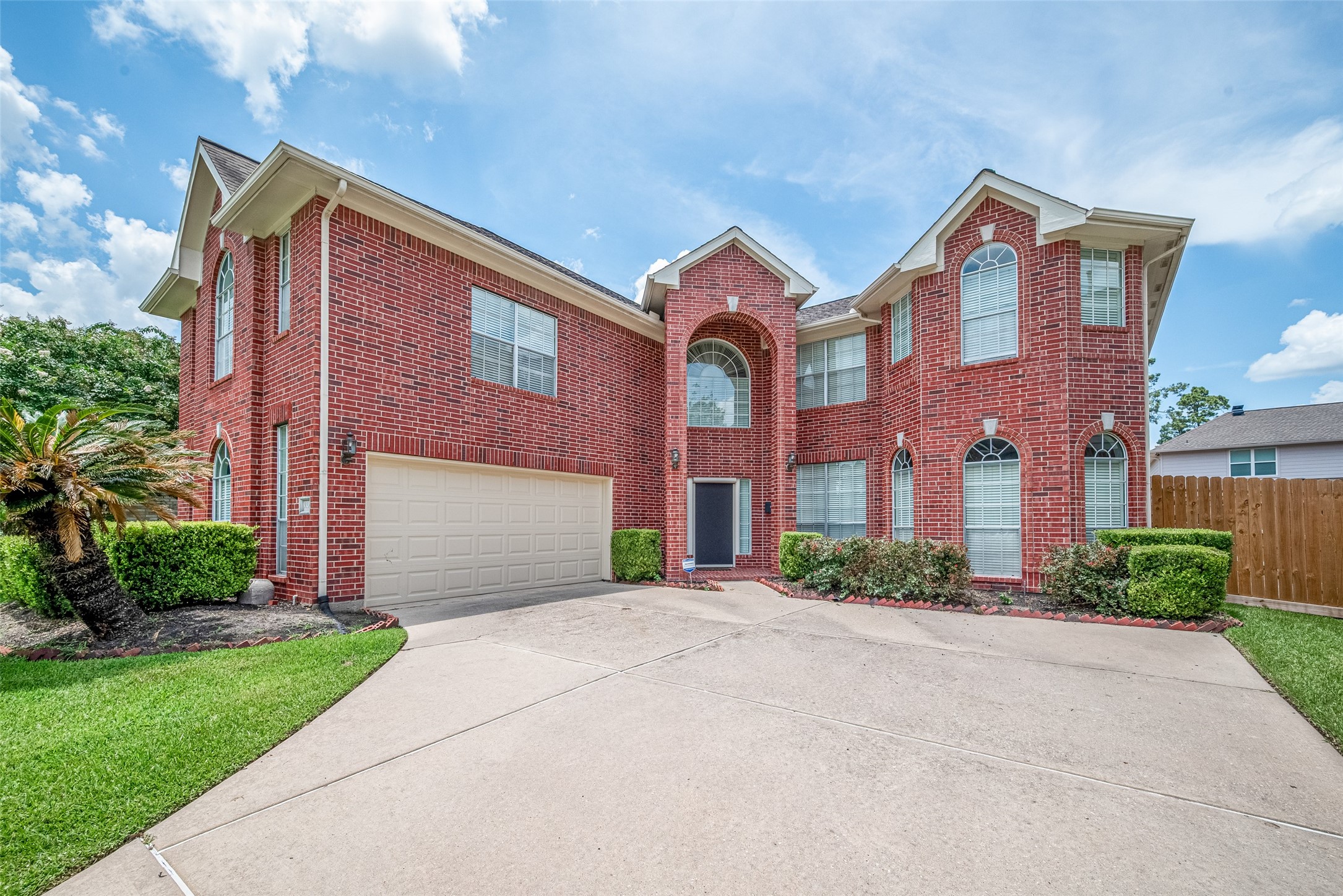 Spacious and elegant  two-story brick home with a two-car garage and well-maintained landscaping, hedges and a lush lawn. The large windows and arched entryway add to its curb appeal. Plenty of parking for your guests and a covered foyer.