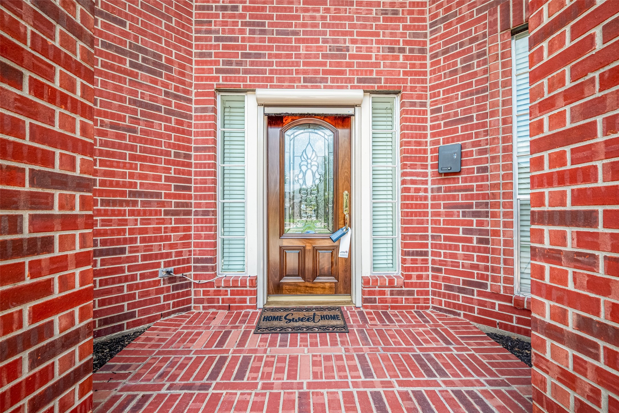9218 Memorial Pines Way Spring, TX 77379 - Photo 3 of 39 Welcoming front entrance with a rich red brick exterior and a decorative door featuring glass inserts. The current owner added a sun curtain for added protection.