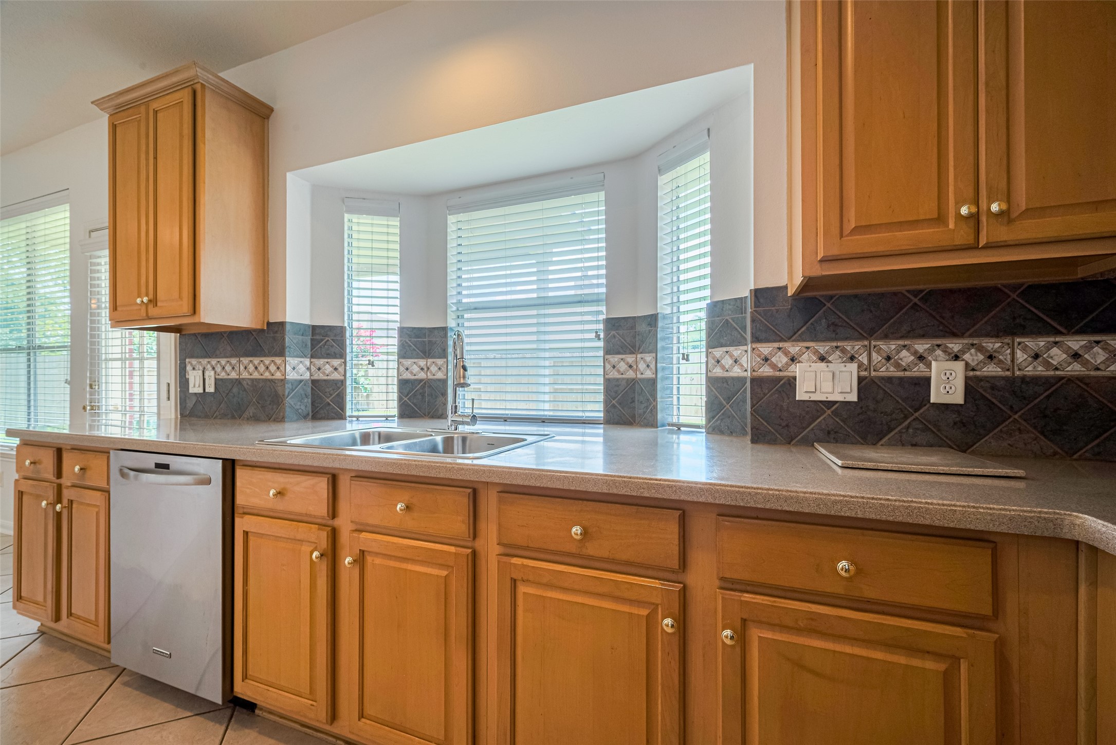 9218 Memorial Pines Way Spring, TX 77379 - Photo 5 of 39 Spacious kitchen with a gas cooktop island and abundant natural light, featuring a window overlooking the backyard.