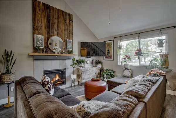a living room with furniture a fireplace and a large window