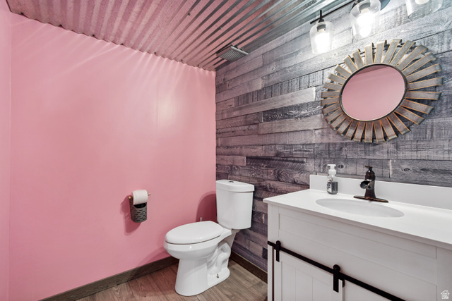7296 Ridge Road Lake Point, UT 84074 - Photo 34 of 54 Bathroom featuring corrugated metal ceiling, wood-finish flooring, and a vanity with a white countertop and barn-door style cabinetry