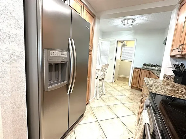 a kitchen with stainless steel appliances granite countertop sink stove and refrigerator