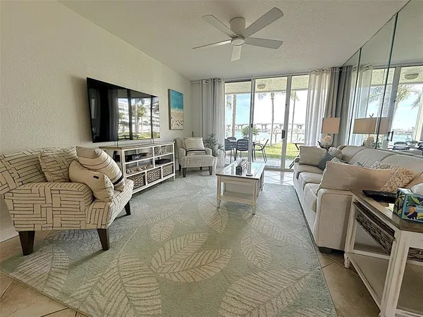 a living room with furniture a flat screen tv and a large window