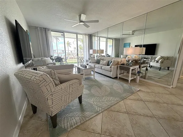 a view of a chairs and table in patio with a view of living room