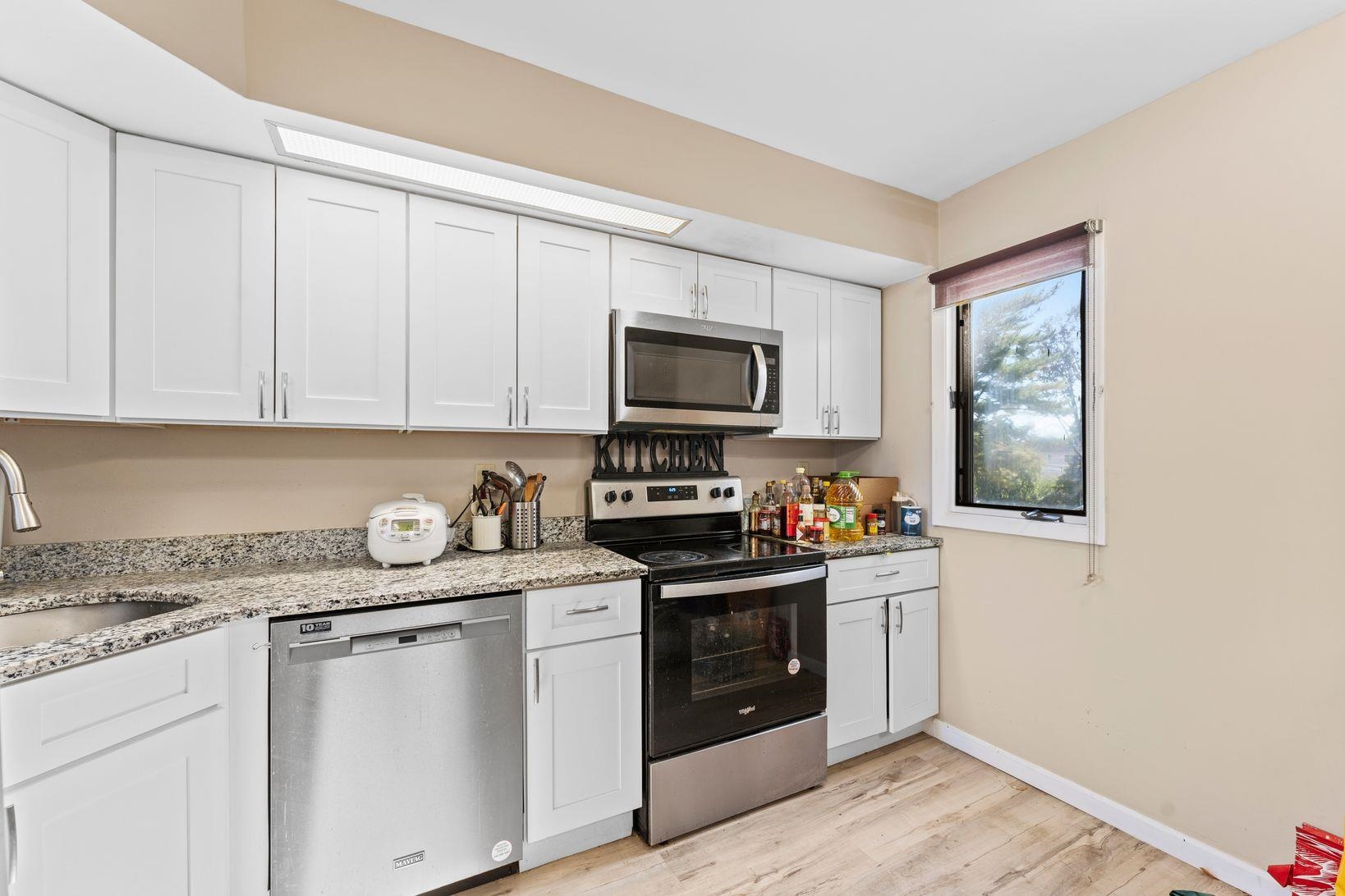 601 River Renaissance East Rutherford, NJ 07073 - Photo 8 of 26 a kitchen with stainless steel appliances granite countertop a stove a sink and a microwave