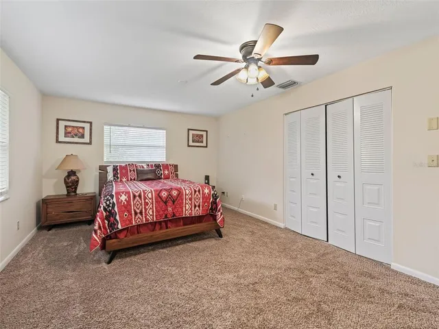 a bedroom with a bed and a flat tv screen on dresser