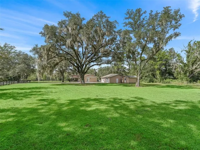 a view of a green field with wooden fence