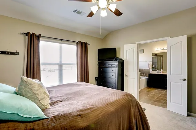 a bedroom with a bed and a large mirror with a flat tv screen