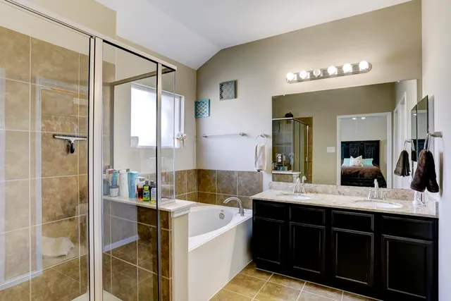 a spacious bathroom with a tub sink and mirror