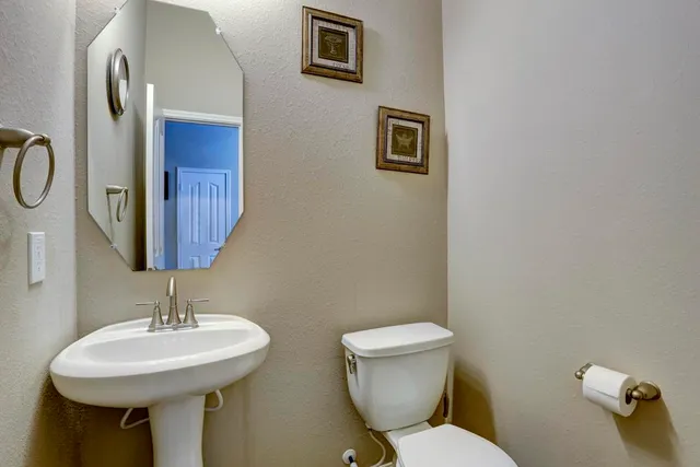 a bathroom with a sink a toilet and a mirror