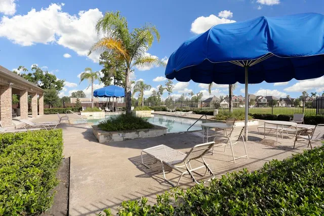 a view of a patio with a table and chairs under an umbrella