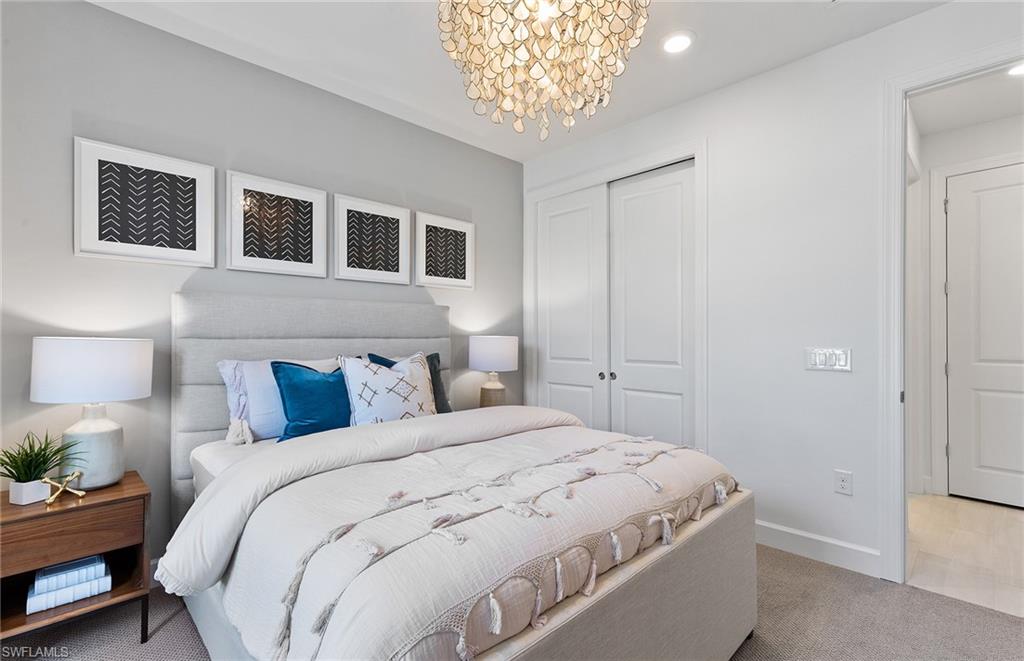 5637 Celebration Drive Immokalee, FL 34142 - Photo 16 of 35 a bedroom with a bed and a chandelier
